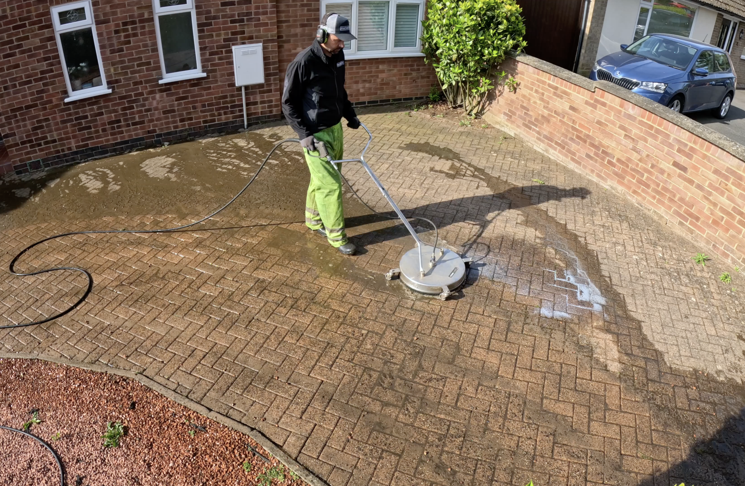 Contractor performing professional pressure washing on a driveway